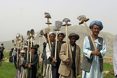 Afghanen mit Werkzeug auf einem Feld