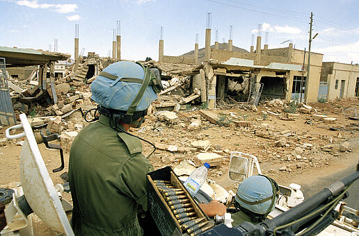 Blauhelmsoldaten der UN fahren auf Panzer durch zerstörtes Gebiet in Eritrea